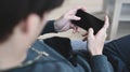 Young man holding horizontal mobile phone with blank screen while lying on couch at home. Royalty Free Stock Photo