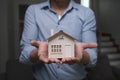 Young man holding house model. Property insurance  and real estate concept. Royalty Free Stock Photo