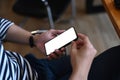 Close up view of young man holding mock up mobile phone with blank screen. Royalty Free Stock Photo