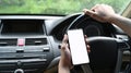 Close up view of man using smart phone while driving car. Royalty Free Stock Photo