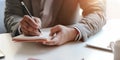 Close-up view of young professional businessman writing his idea concepts on notebook Royalty Free Stock Photo