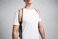 Close-up view of young stylish guy in blank white t-shirt and backpack
