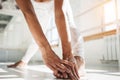 Close up view on young taned fit woman doing stretching exercises leg in white interior gym Royalty Free Stock Photo