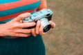 A young woman is carrying a vintage camera outdoor