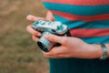 A young woman is carrying a vintage camera outdoor