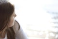 Close up view of a young woman looking out at the water