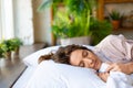 Close up view - a young woman is sleeping embracing a blanket. The concept of recuperation and healthy sleep.