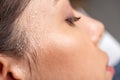 View of young woman with sweaty face suffering from heat on grey