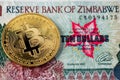 A close up view of Zimbabwe hyperinflation banknote and Bitcoin. Hyperinflation