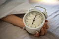 Close up vintage clock in a boy hand, showing time 6 am , 7oclock in the morning. Royalty Free Stock Photo
