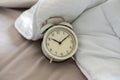 Close up the vintage clock 10.10 o`clock 10pm in the bed with white blanket, bedroom background Royalty Free Stock Photo