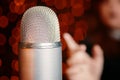 Woman pulls hand to microphone for sing at concert. Royalty Free Stock Photo