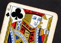 Close up of a vintage jack of clubs playing card on a black background.