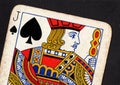 Close up of a vintage jack of spades playing card on a black background.