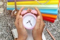 Close up a vintage pink alarm clock in the hands of a woman Royalty Free Stock Photo