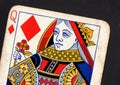 Close up of a vintage queen of diamonds playing card on a black background. Royalty Free Stock Photo