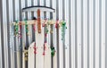 Close up of a vintage sled decorated with red, gold and green Christmas curling ribbon, leaning against a wall