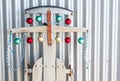 Close up of a vintage sled decorated with red, gold and green satin Christmas ornaments, leaning against a wall