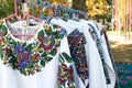Close up of vintage ukrainian clothes, vyshyvanka - traditional embroidered shirts on flea market or national festival