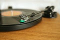 Close-up of vinyl record playing on turntable with focus on tonearm Royalty Free Stock Photo