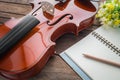 Close up of violin and book on wooden table Royalty Free Stock Photo