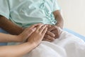 Close up of visitor holding senior patient`s hand in hospital, health care and medical concept Royalty Free Stock Photo