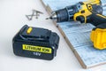 18 volt recharge Li-ion battery for electric cordless drill on white.Blurred screwdriver,screws on boards.Copy space