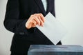 Close-up of voter putting ballot into voting box