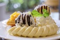 close up waffles served with mixed fruits, sliced banana, ice-cream and topped with chocolate Sauce