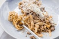 Close up Wagyu Ragu with Tagliatelle pasta topping with cheddar cheese. Rolled spaghetti with fork Royalty Free Stock Photo