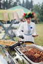 Close-up waiter female wearing traditional Uzbek dress hand putting grilled piece of meat