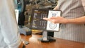 Close up of waitress hand showing coffee menu on digital tablet  to customer for ordering at counter coffee shop, small business Royalty Free Stock Photo