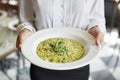 Close Up Of Waitress Holding Plate Of Pea And Mint Risotto In Restaurant Royalty Free Stock Photo