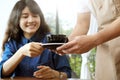 Close-up of a waitress serving a cup of coffee to young beautiful customer. Royalty Free Stock Photo