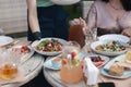 Close up of waitress tup salad on served table at summer terrace. Evening dinner with family. Food concept. Different Royalty Free Stock Photo