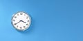 Close-up wall clock set on blue background. The concept of The time is going on. Copy space