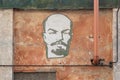 Close-up wall engraving lenin head red pipe old courtyard shabby plaster