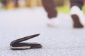 Close-up of wallet lying on the road  lost leather wallet with money on the street. Royalty Free Stock Photo