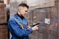 Close up of warehouse worker scanning barcodes on boxes in a large warehouse