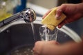 Close up washing dishes. male hands in foam washes the frying pa