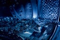 Close-up of a washing machine drum with water. Beautiful image with blue light tinting Royalty Free Stock Photo