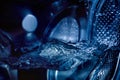 Close-up of a washing machine drum with water. Beautiful image with blue light tinting Royalty Free Stock Photo