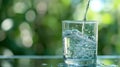 Close-up of water being poured into a glass against blurred greenery background Royalty Free Stock Photo