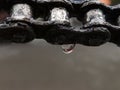 close-up of water dripping on an old, rusty motorcycle chain