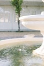 Close up on water dripping out of white stone fountain in beautiful spring flower garden. Shallow Depth of Field Royalty Free Stock Photo