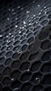 Close-up of water droplets on a dark hexagonal mesh surface creating a textured and abstract pattern Royalty Free Stock Photo