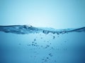 Close up water droplets forming on clear blue liquid surface Royalty Free Stock Photo