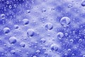 Close-up on water drops background on blue surface. Water droplets on glass with reflections in them. Royalty Free Stock Photo