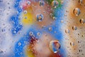 Close up on water drops background on blue, yellow, brown surface. Water droplets with reflections in them. Royalty Free Stock Photo