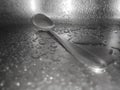 Close-up of water drops on the sink with a metal spoon. Royalty Free Stock Photo